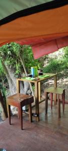 a patio with two tables and chairs and a tent at Jungle Glamping Tent in Maluk