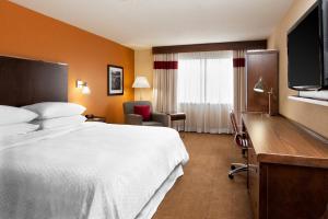 Habitación de hotel con cama, escritorio y TV. en Four Points by Sheraton Edmundston Hotel & Conference Center, en Edmundston