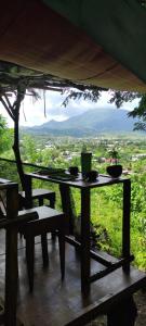 a table and chairs on a porch with a view at Jungle Glamping Tent in Maluk