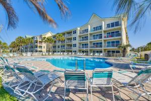 a resort with a swimming pool with chairs and a building at Well-Appointed Family Condo on Miramar Beach! in Destin