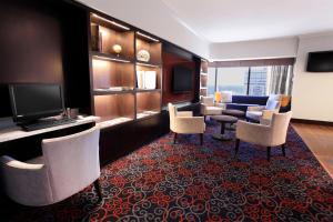 une chambre d'hôtel avec un canapé, des chaises et une télévision dans l'établissement Delta Hotels by Marriott London Armouries, à London