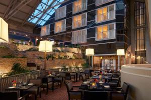 un restaurante con mesas y sillas y un edificio en Delta Hotels by Marriott London Armouries, en London