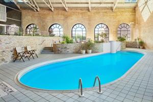 une grande piscine bleue dans un bâtiment dans l'établissement Delta Hotels by Marriott London Armouries, à London