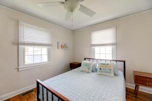 a bedroom with a bed with a ceiling fan and windows at North Carolina Retreat - Deck, Grill and Creek Views in Beaufort
