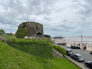 uma parede de pedra no lado de uma estrada perto da praia em The Studio by Hip Haus em Cleethorpes