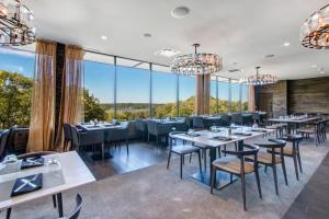 YOUR New Luxury Lakeview Condo w Pool Access في بحيرة جنيف: مطعم بطاولات وكراسي ونوافذ كبيرة