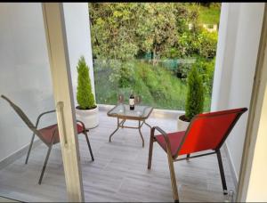 a patio with two chairs and a table and a window at Mirador samsara in La Calera