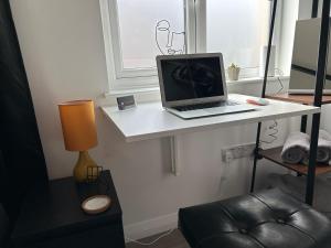 a laptop computer sitting on a white desk in a room at The Studio by Hip Haus in Cleethorpes