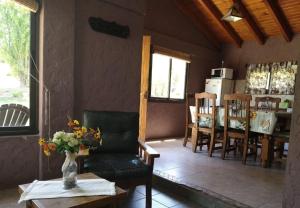 sala de estar con sofá, mesa y sillas en CABAÑAS VILLA CAMPESTRE en Potrerillos