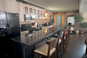 a kitchen with a black counter and some chairs at Inspiring Grotto Sleeps 10-20 Free TV & Parking in Chicago