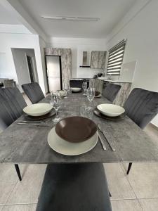 a dining table with plates and wine glasses on it at Villa Meropi in Paphos