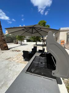 a grill with an umbrella on a patio at Villa Meropi in Paphos City