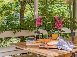ein Holztisch mit einem Tablett mit Essen und Blumen in der Unterkunft Leura Country Cottage in Leura