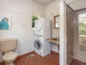 a bathroom with a washing machine and a sink at Leura Country Cottage in Leura