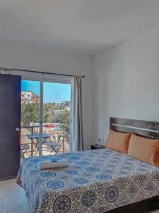 1 dormitorio con 1 cama y balcón en La Aurora, en Puerto Escondido