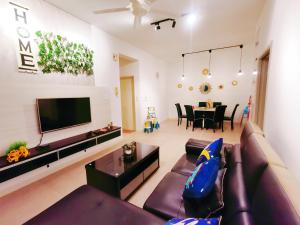 a living room with a couch and a television at Legoland-3min Walk-HappyDream Suite at Afiniti -8pax-Cozy,Comfy&Convenience 2BR with Bathub in Nusajaya