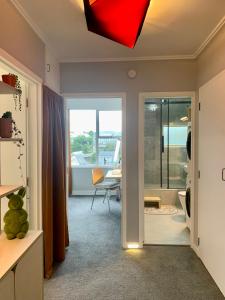 ein Wohnzimmer mit einer Tür, die in ein Zimmer mit einem Tisch führt in der Unterkunft Central Nest- view & style in Wellington
