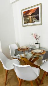 a dining room with a glass table and white chairs at Beach House Holiday in Neoi Epivates