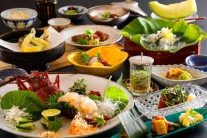 a table with plates of food and bowls of food at Temple Town Hotel WAQOO Horyuji in Ikaruga