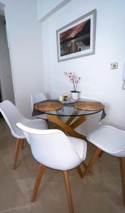 a dining room with two tables and white chairs at Beach House Holiday in Neoi Epivates