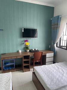 a bedroom with a desk with a computer and a bed at Kim Ngân Motel in Chau Doc