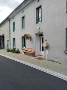 a wooden bench sitting outside of a building at Chambre gîte du Gardoir in Boresse-et-Martron