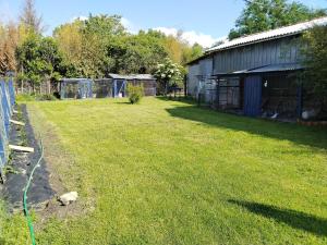 a yard with a fence and a building at Chambre gîte du Gardoir in Boresse-et-Martron