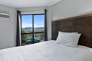 a bedroom with a bed and a window with a view at The Vista Inn in Kamloops