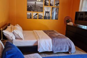 um quarto com uma cama e algumas fotografias na parede em Kalimera A Lovely 1-bedroom rental with ensuite and parking em Limassol