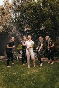 a group of women standing around a man in the grass at Laurant's Cottage ~ McLaren Vale entertainer in McLaren Vale