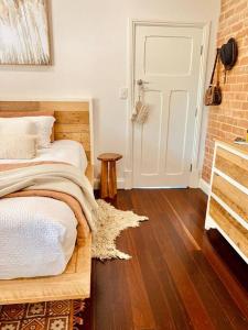 ein Schlafzimmer mit einem Bett und einer Ziegelwand in der Unterkunft Laurant's Cottage ~ McLaren Vale entertainer in McLaren Vale