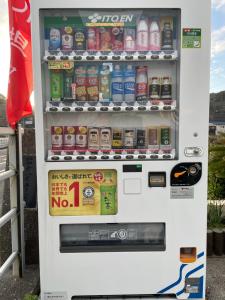 Una máquina expendedora blanca con bebidas. en Uhome Kamogawa 本館-【ペット可/広い2LDK】, en Kamogawa