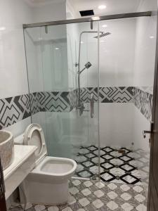 a bathroom with a toilet and a glass shower at Kim Ngân Motel in Chau Doc