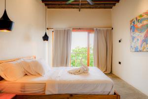 a bedroom with a white bed with a window at Seascapes Bira in Bira