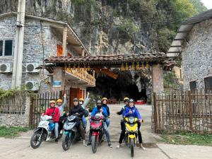 un grupo de personas en motocicletas frente a un túnel en Min's Ha Giang Hostel, en Ha Giang