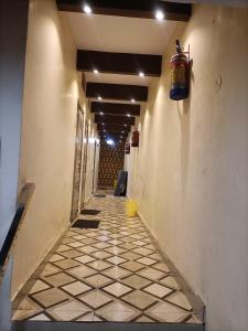 a long hallway with a tile floor and a bucket on the wall at OYO Hotel Yash Galaxy in Kānpur