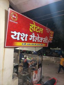 a sign for a food stand with a man preparing food at OYO Hotel Yash Galaxy in Kānpur