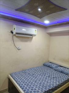 a small room with a bed with a air conditioner at OYO Hotel Yash Galaxy in Kānpur