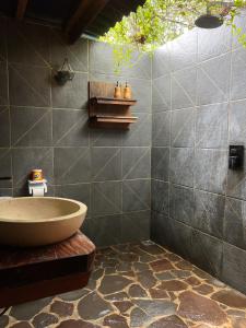 a bathroom with a tub and a tiled wall at Seascapes Bira in Bira