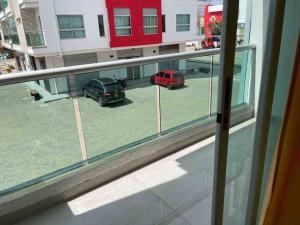 uma janela com dois carros estacionados num parque de estacionamento em Apartamento en Coveñas cerca al mar #204 em Coveñas