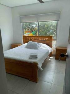 um quarto com uma cama e uma grande janela em Apartamento en Coveñas cerca al mar #204 em Coveñas