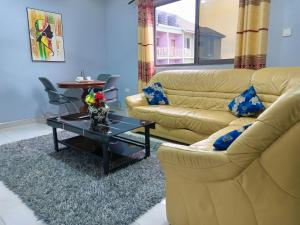een woonkamer met een bank en een salontafel bij Indigo cottage and Apartment in Kumasi