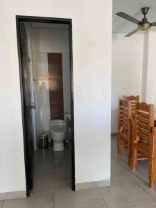 W łazience znajduje się toaleta i wentylator sufitowy. w obiekcie Apartamento en coveñas cerca al mar #202 w mieście Coveñas
