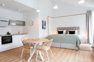 Moderne neue Apartments zum Wohlfühlen im Boardinghouse bed & butter في Hasbergen: غرفة نوم بسرير وطاولة وكراسي