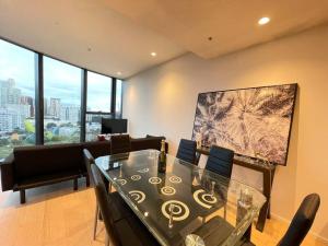 a dining room with a glass table and chairs at City View Luxury 3 Bedroom Apartment-Free Car Park in Melbourne