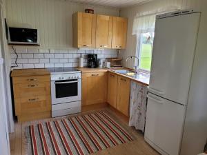 沃爾高達的住宿－Sommarstuga，厨房配有白色冰箱和木制橱柜。