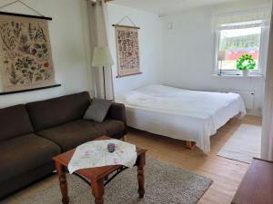 a living room with a couch and a bed at Sommarstuga in Vårgårda