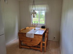 沃爾高達的住宿－Sommarstuga，一间带木桌和窗户的用餐室