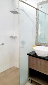 Baño blanco con lavabo y espejo en Surokarsan 9 House Yogyakarta en Yogyakarta