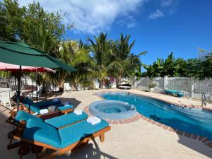 a swimming pool with blue lounge chairs and a swimming pool at Ocean View with Pool, 4 bedroom Vila Near Key West in Cudjoe Key